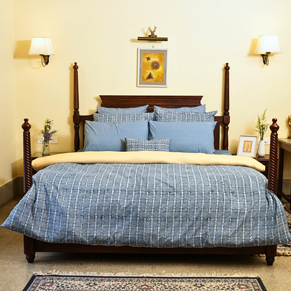 Bedroom with blue checkered bedding, and decorative pillows.