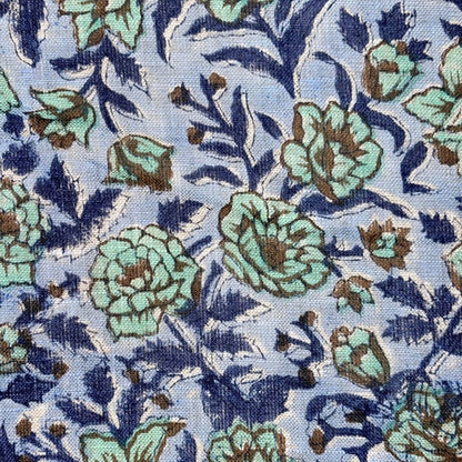 Floral patterned fabric with blue and green flowers on a blue background