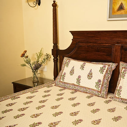 Bedroom with floral-patterned bedding and pillows on a wooden bed.