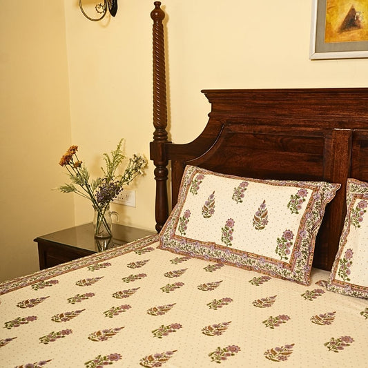 Bedroom with floral-patterned bedding and pillows on a wooden bed.