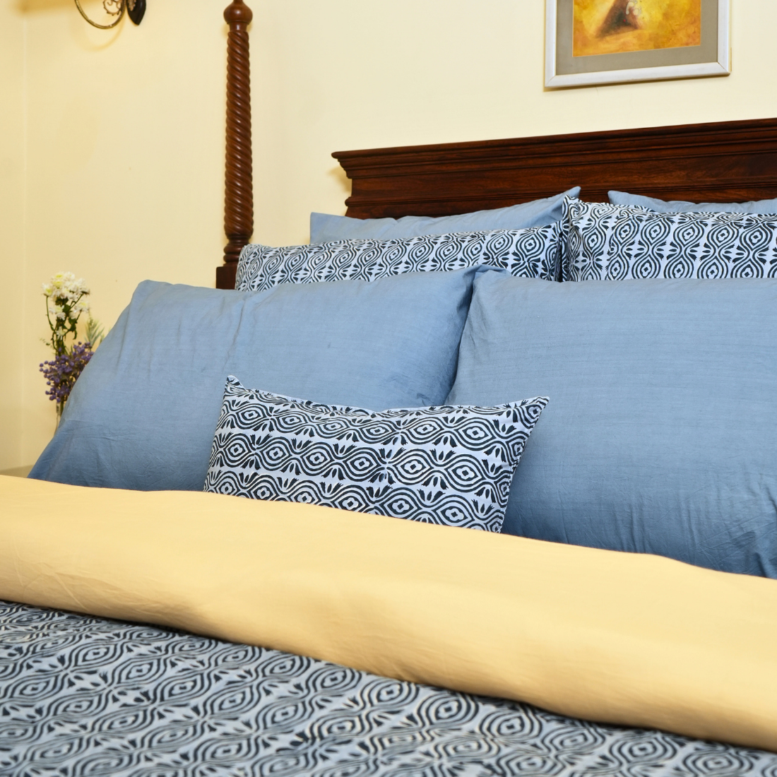 Blue and patterned pillows on a bed .