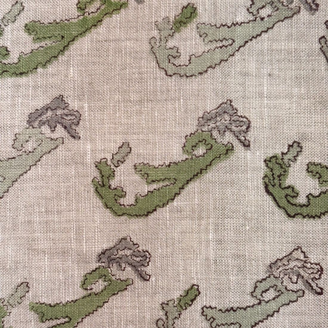Textile pattern with green and brown abstract shapes on a grey background