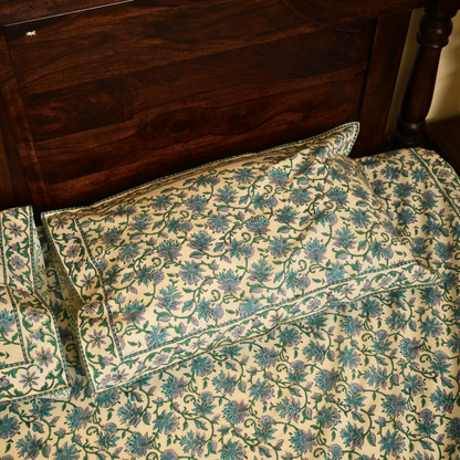 Floral patterned pillows on a bed with wooden headboard