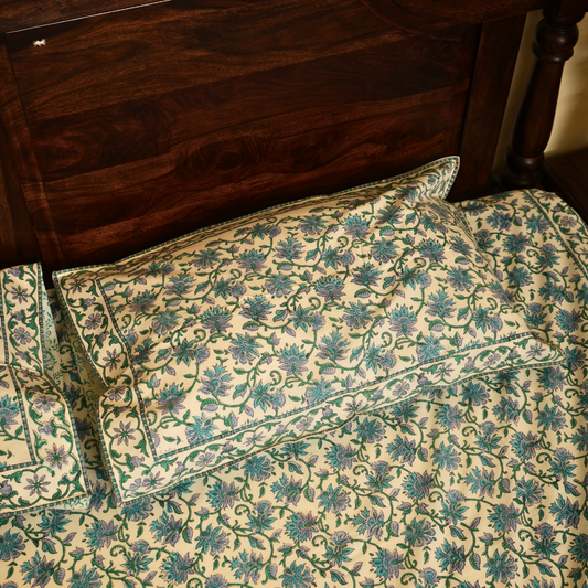 Floral patterned pillows on a bed with wooden headboard