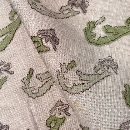 Close-up of fabric with green and brown leaf pattern on a grey background