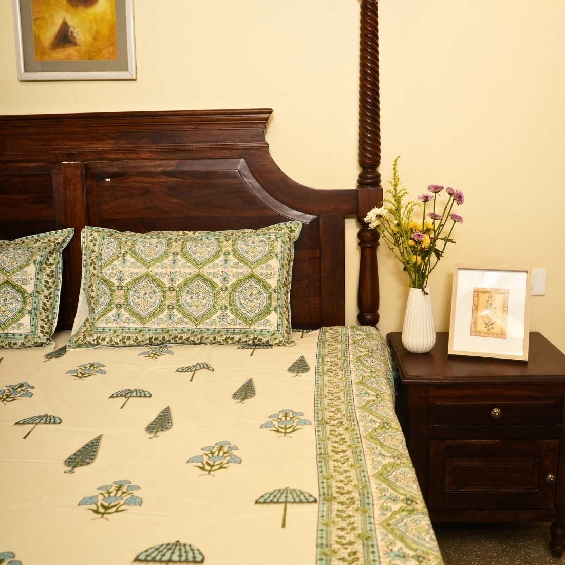 Bedroom with floral bedspread, wooden headboard, and decorative pillows.