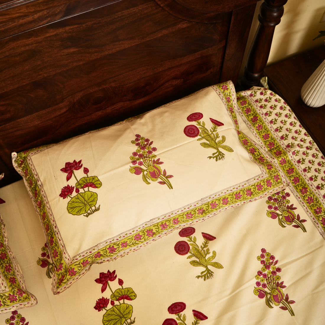 Decorative pillow with floral embroidery on a wooden bed frame.