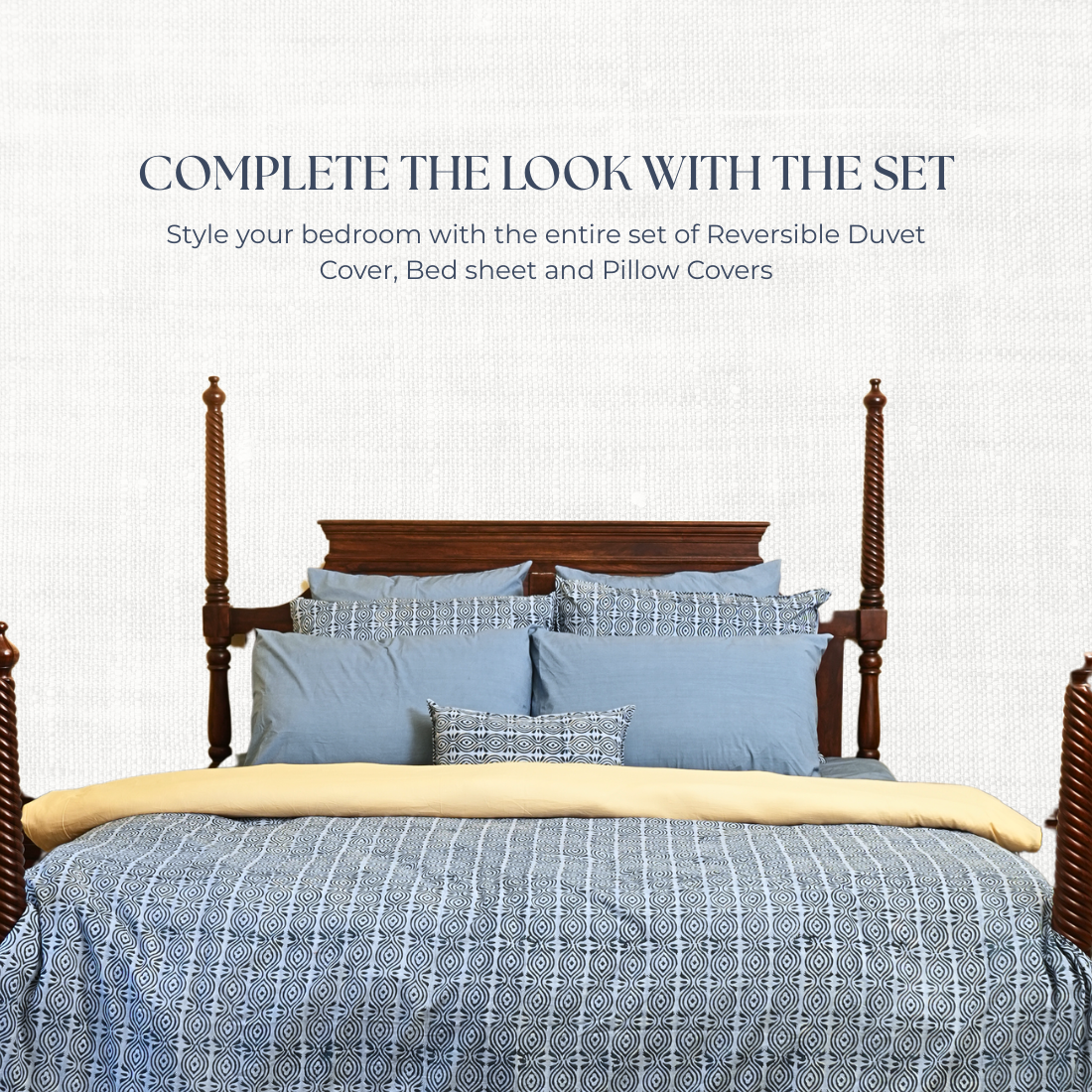Bed with blue bedding set and wooden headboard on a white background