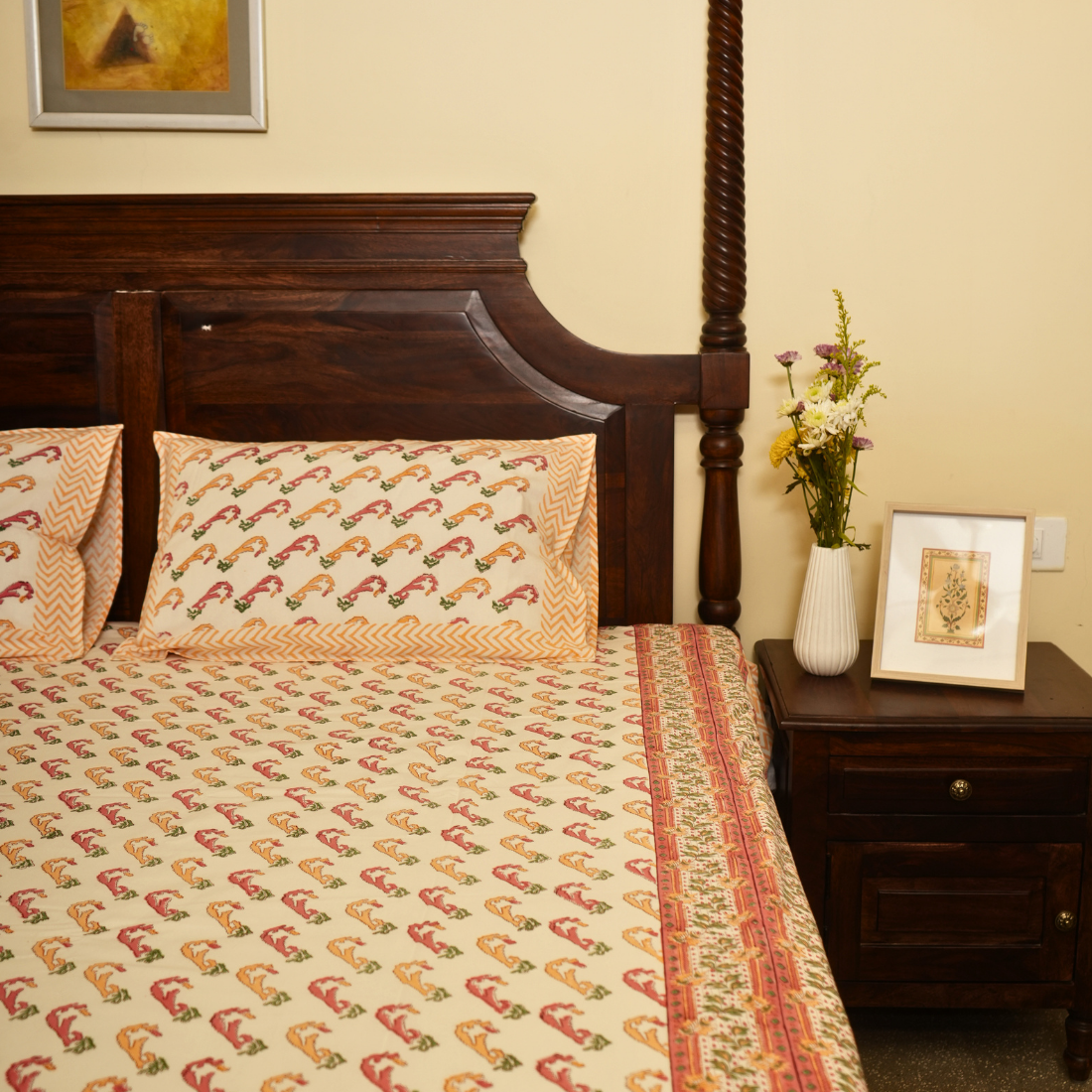 Bedroom with a wooden bed, patterned bedding, and decorative items on a nightstand.