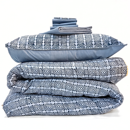 Stack of blue and white patterned bedding on a white background