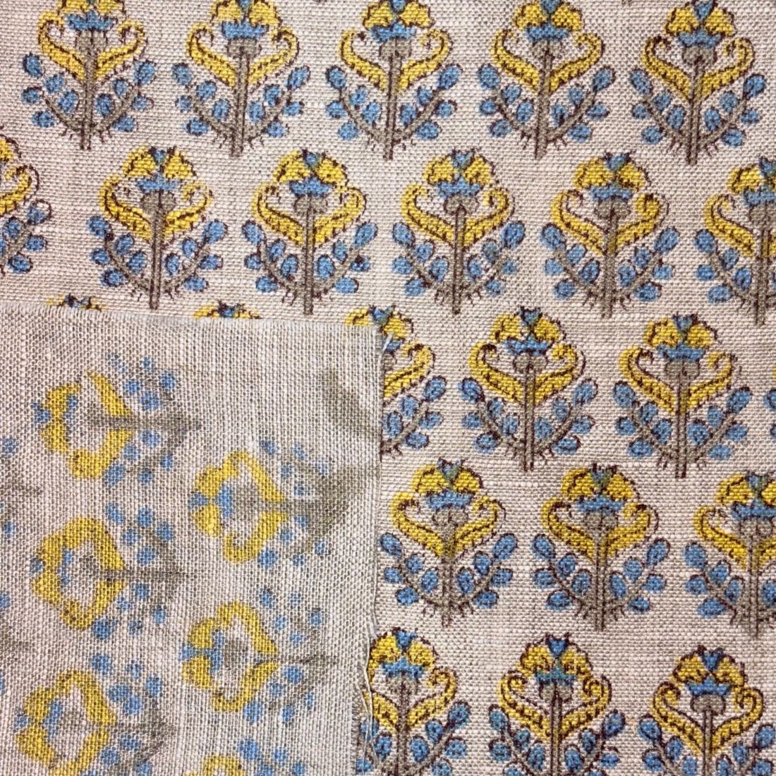 Patterned fabric with blue and yellow design on a grey background
