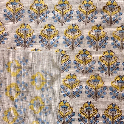Patterned fabric with blue and yellow design on a grey background