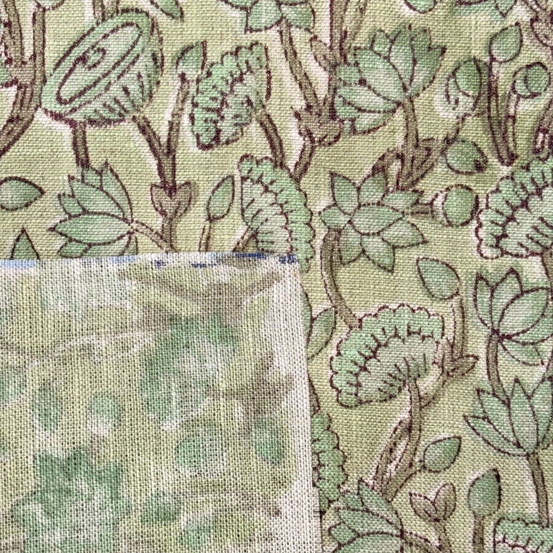 Close-up of fabric with green floral pattern and texture swatch.