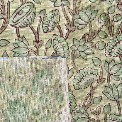 Close-up of fabric with green floral pattern and texture swatch.