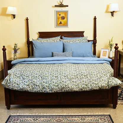 Bedroom with floral bedding, and decorative pillows.