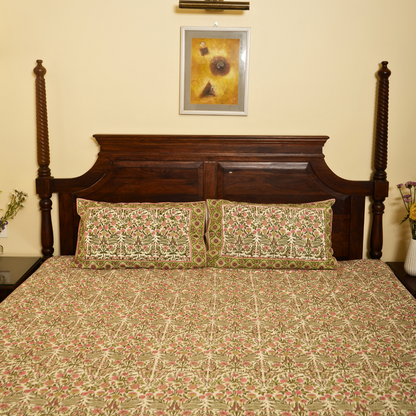 Bed with floral bedding and wooden headboard against a beige wall with a framed picture.