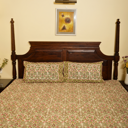 Bed with floral bedding and wooden headboard against a beige wall with a framed picture.