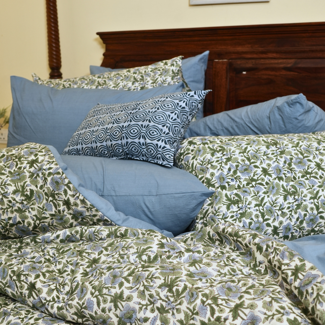 Bed with floral and blue bedding and pillows