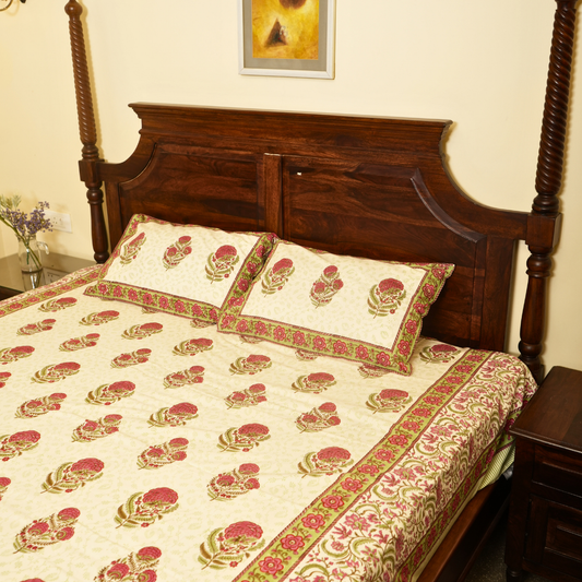 Bed with floral patterned bedding and wooden headboard in a room.