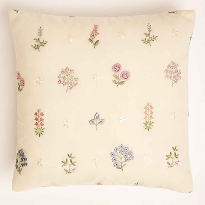 Decorative pillow with embroided patterns on a plain background