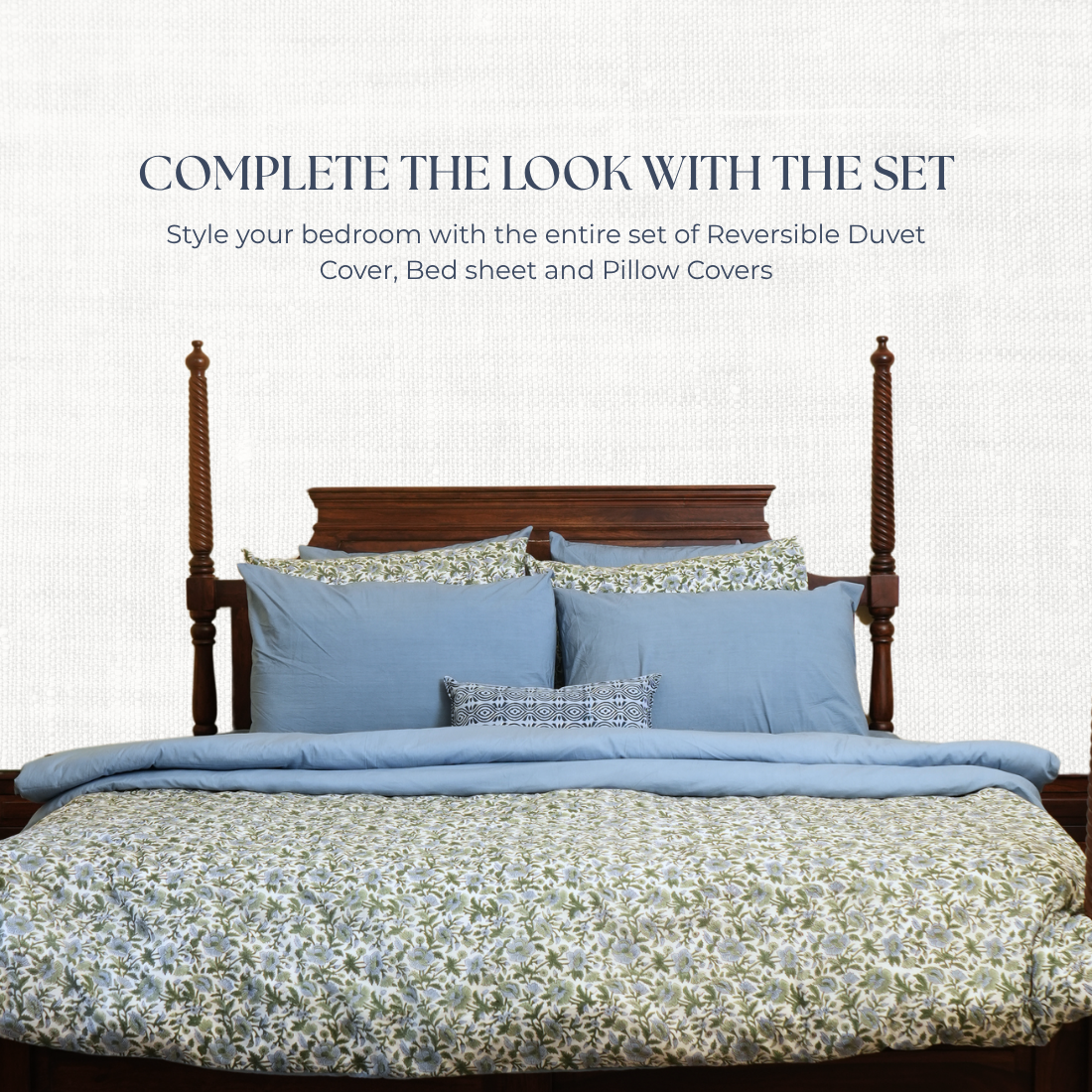 Bed with blue bedding set and floral patterns on a white background