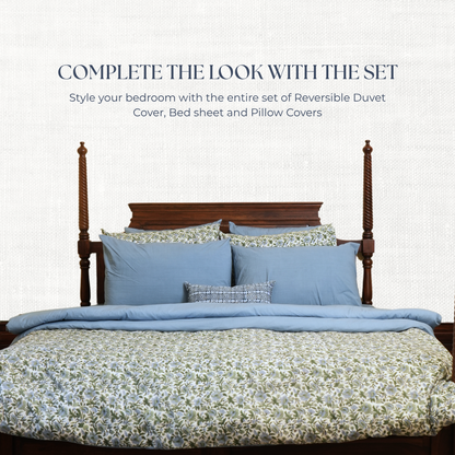 Bed with blue bedding set and floral patterns on a white background