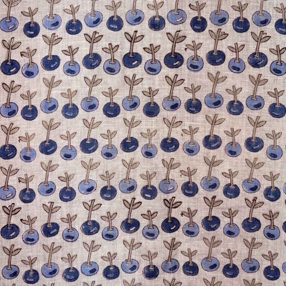 Pattern of blue berries with stems on a grey background