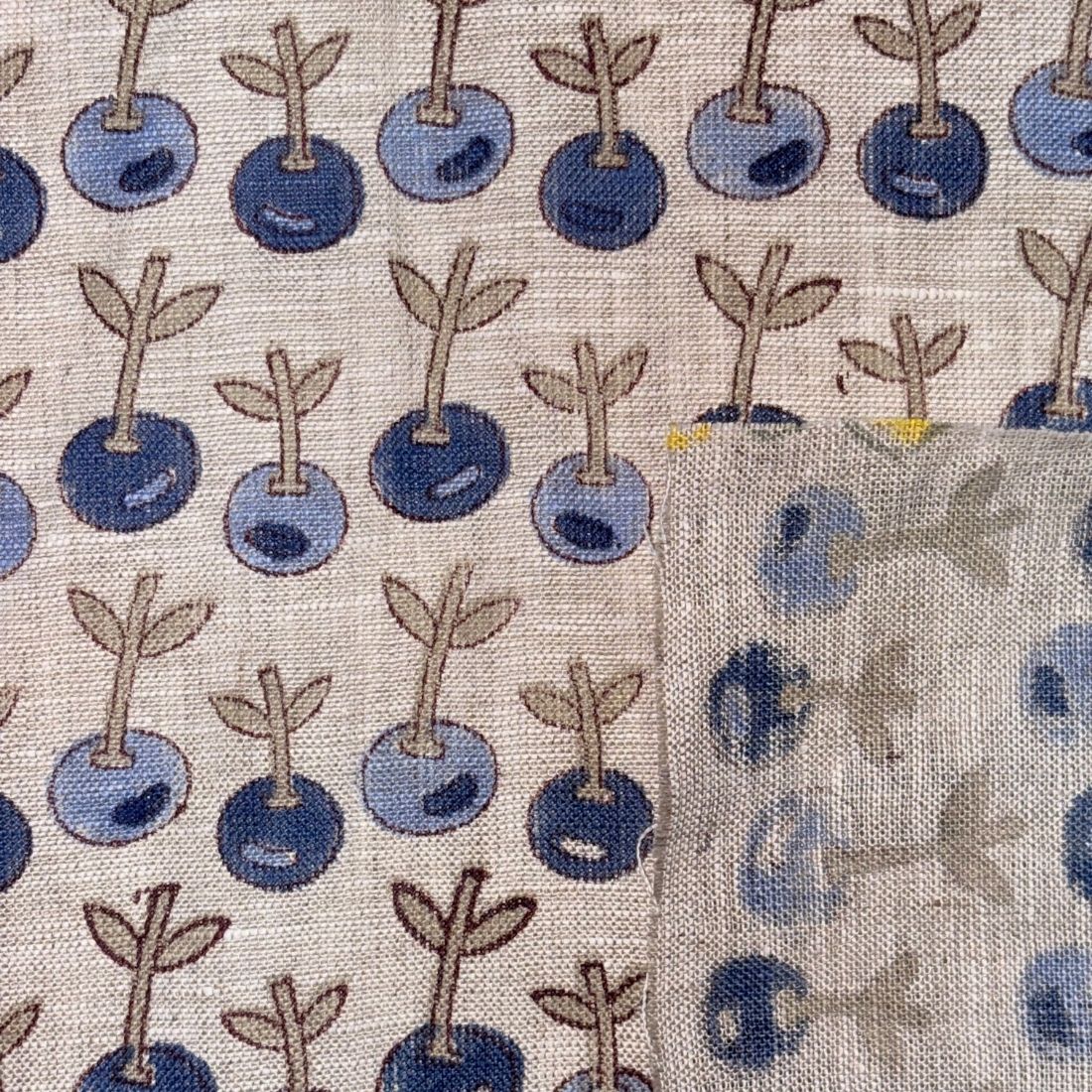 Pattern of blue berries with stems on a grey background
