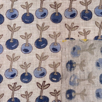 Pattern of blue berries with stems on a grey background