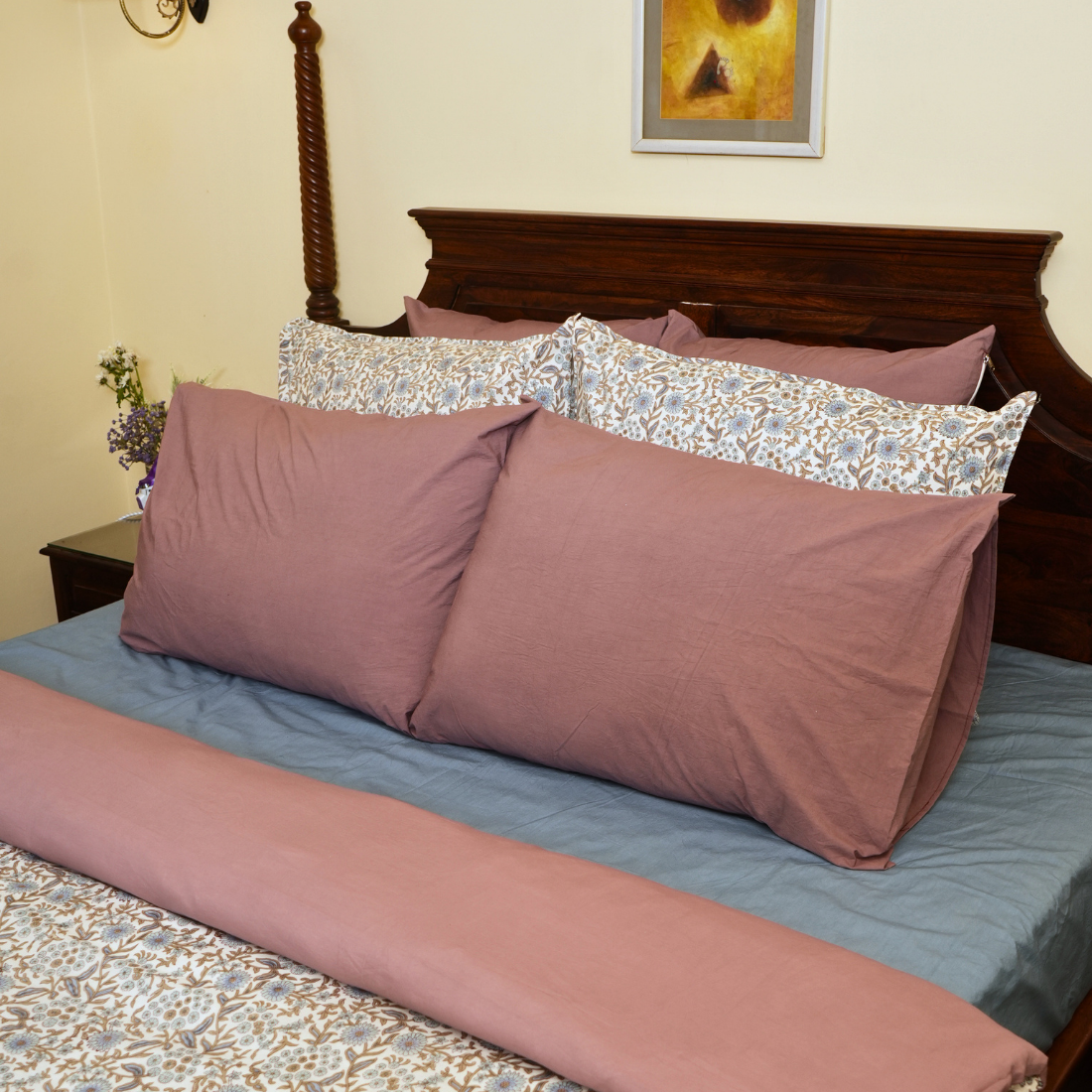 Bed with floral and solid-colored pillows.
