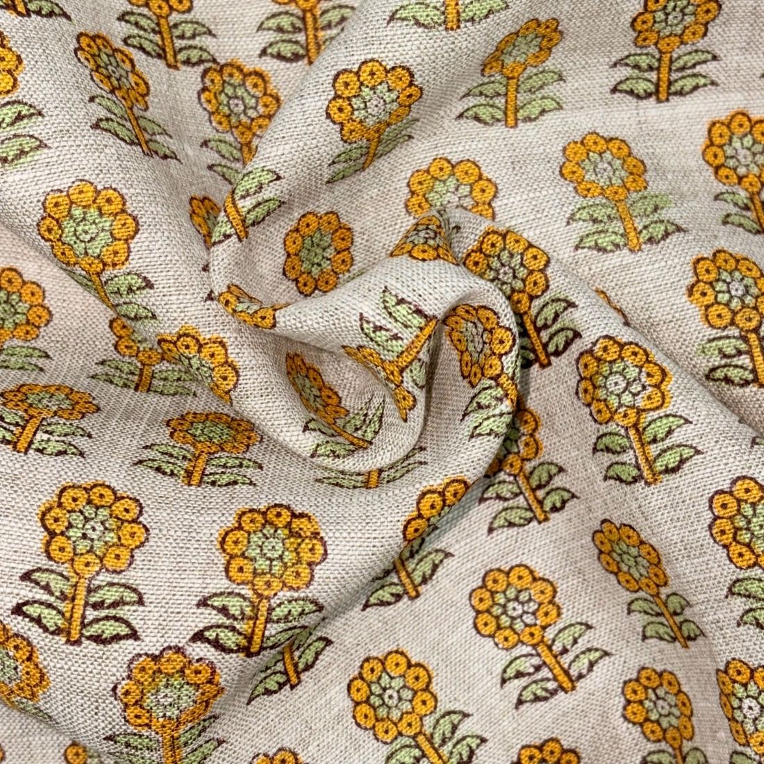 Floral patterned fabric with yellow and green flowers on a grey background