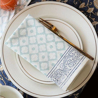Plated dish with patterned napkin and fork on a decorative tablecloth