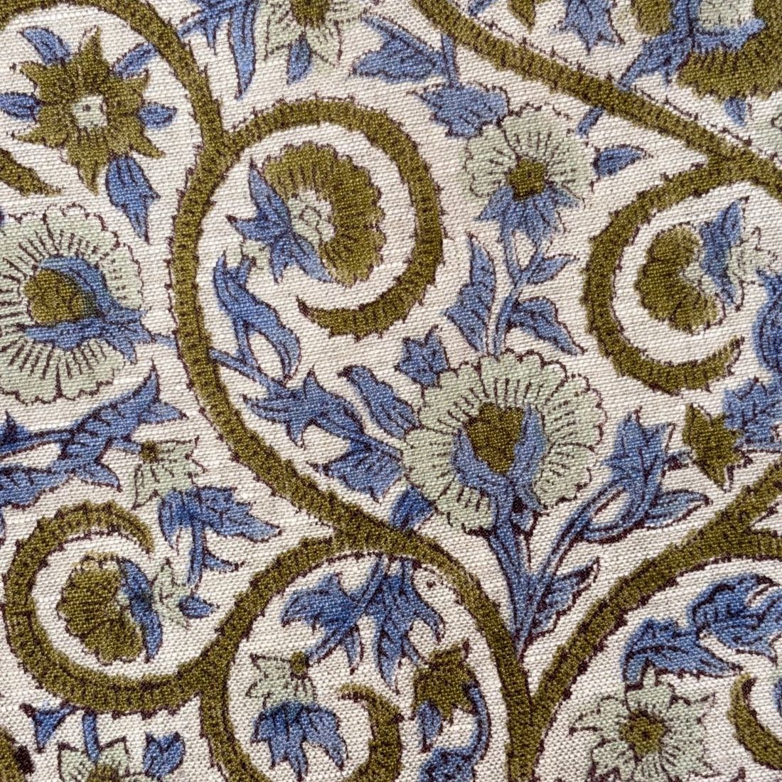 Close-up of a floral patterned fabric with blue and brown colors on a beige background.