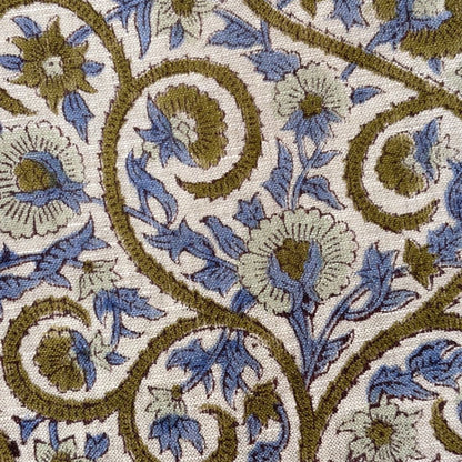 Close-up of a floral patterned fabric with blue and brown colors on a beige background.