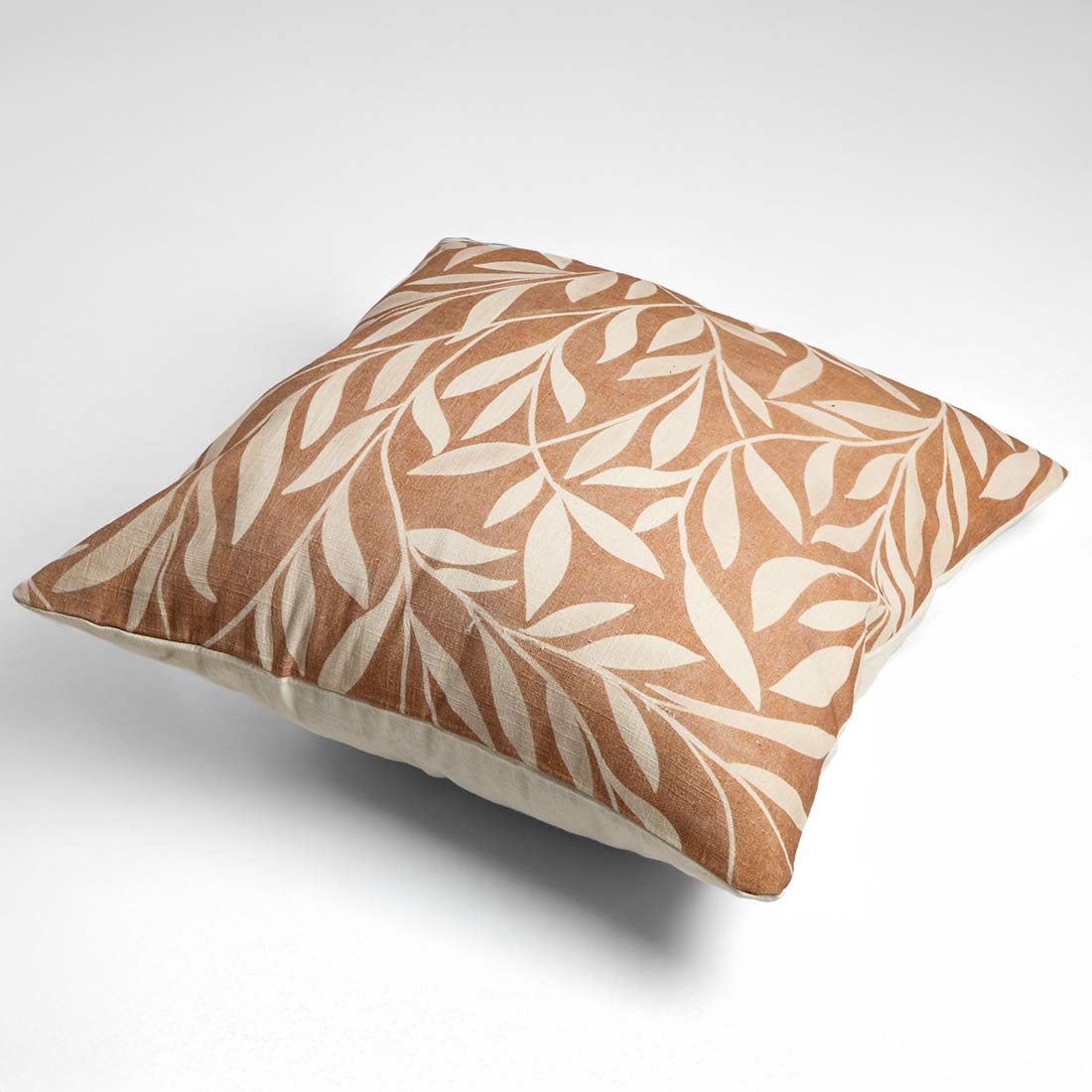 Decorative pillow with leaf pattern on a white background