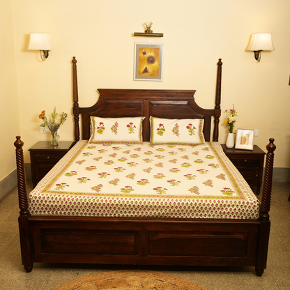 Bedroom with a wooden bed and floral bedding, two nightstands with lamps and decor.