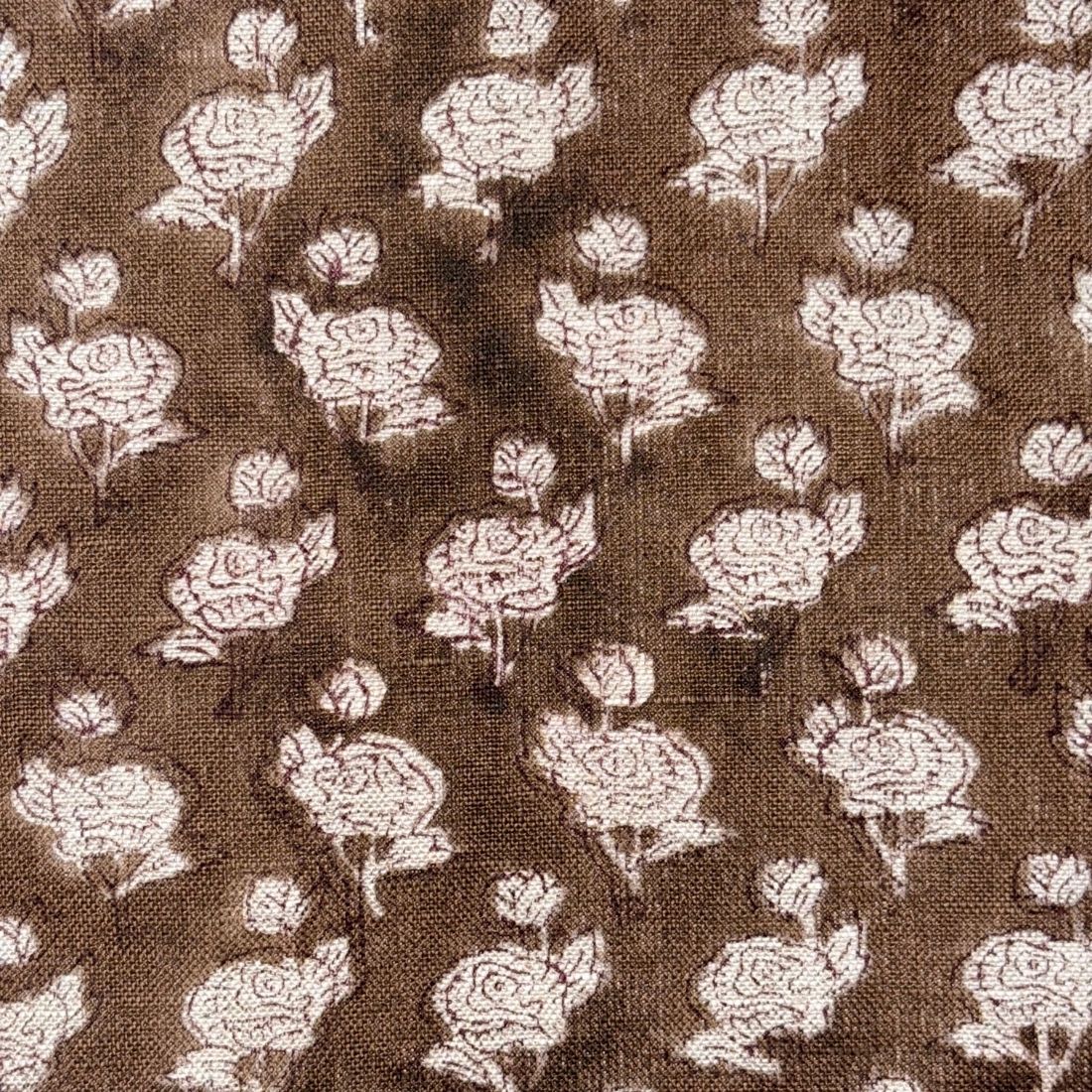 Floral pattern on fabric with white flowers on a brown background