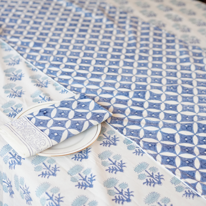 Blue and white patterned tablecloth with a folded napkin on a white surface