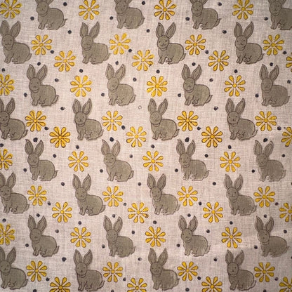Pattern of gray rabbits and yellow flowers on a grey background