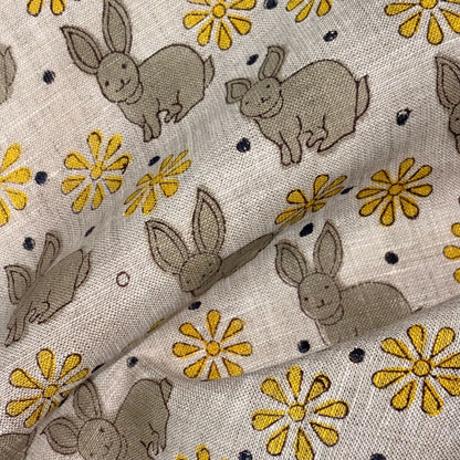 Fabric with embroidered bunnies and flowers on a grey background