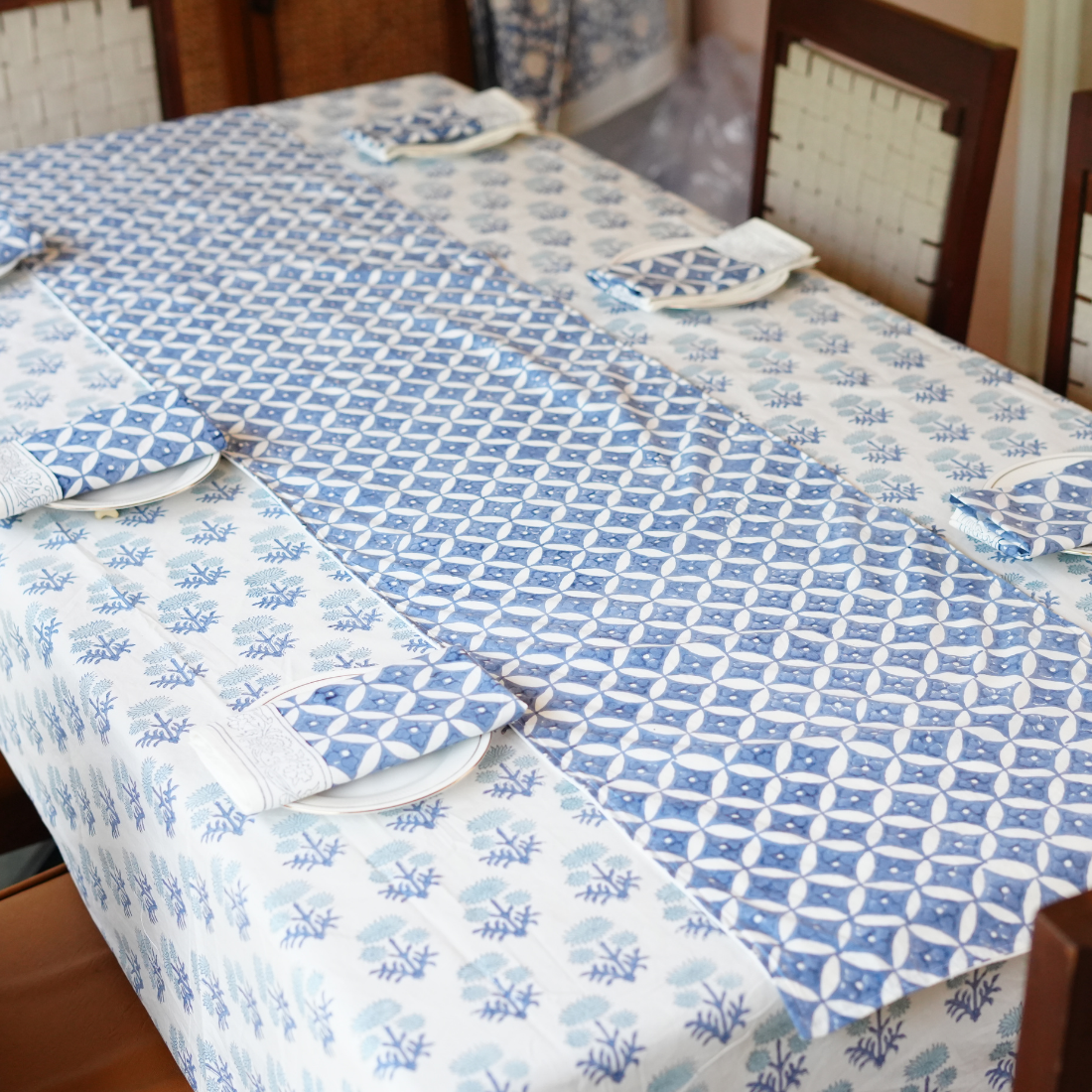 Table linen set with blue geometric and floral pattern on a dining table