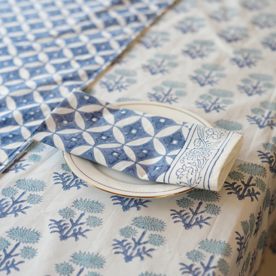 Patterned table linen set with geometric and floral designs on a table.