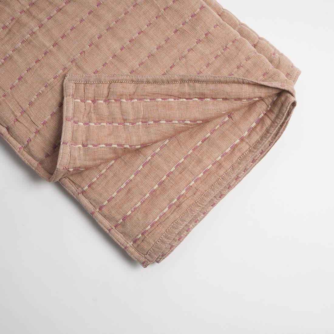 Folded throw with a subtle pattern on a light gray background
