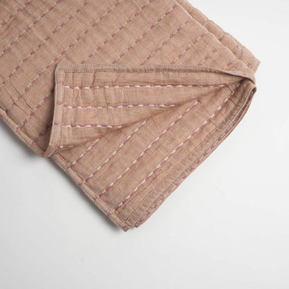 Folded throw with a subtle pattern on a light gray background