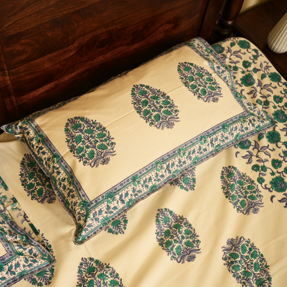 Decorative bedspread with intricate green and purple patterns on a beige background.