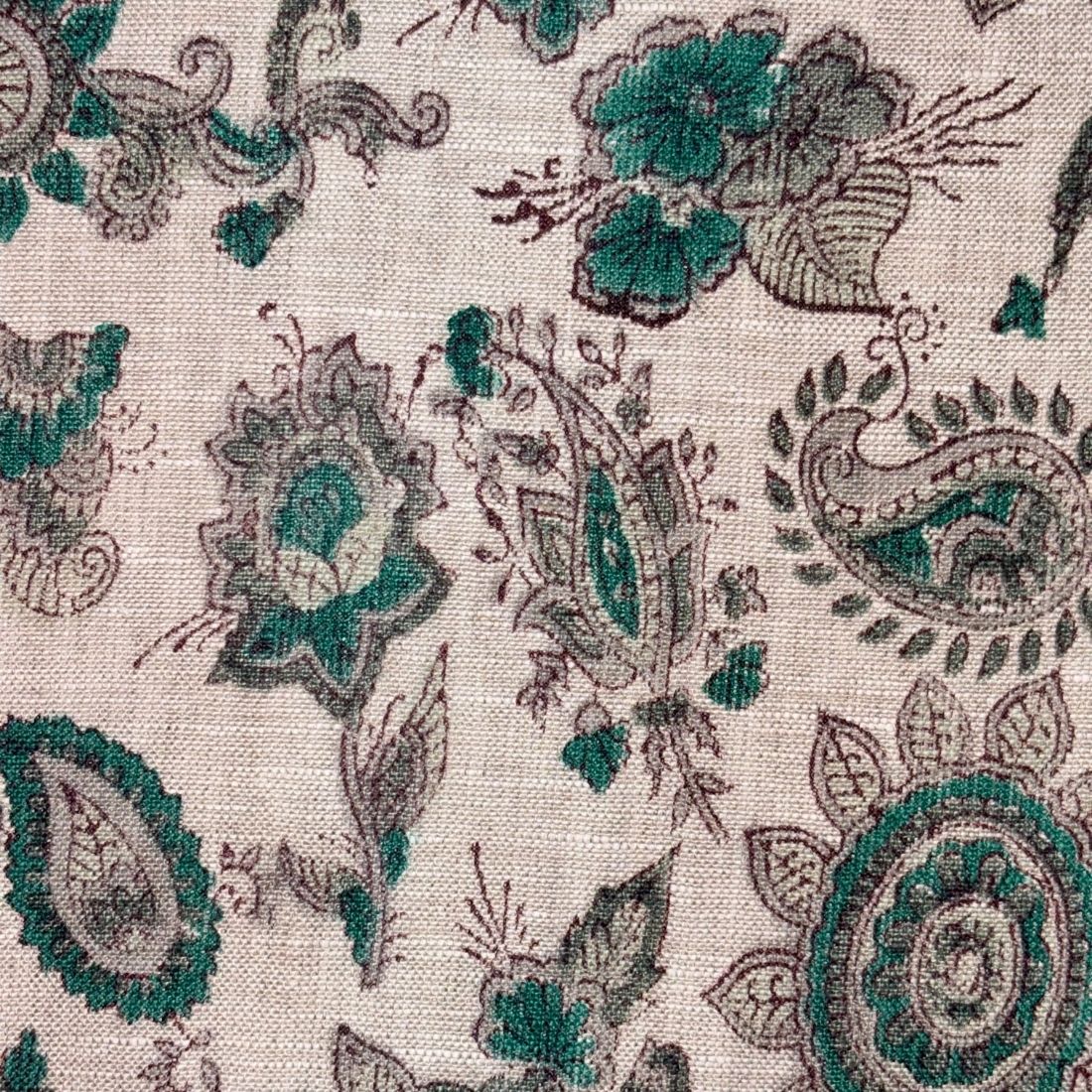 Close-up of a fabric with intricate paisley pattern in green and brown on a grey background