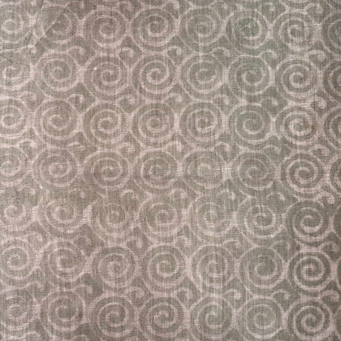 Patterned fabric with spiral design in beige on a grey background
