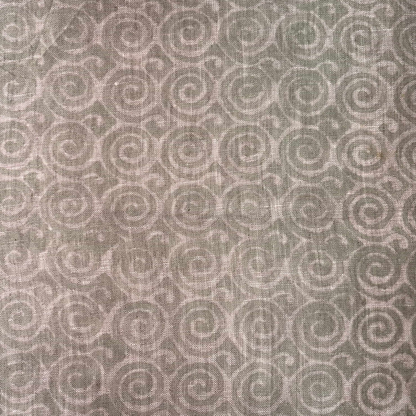 Patterned fabric with spiral design in beige on a grey background