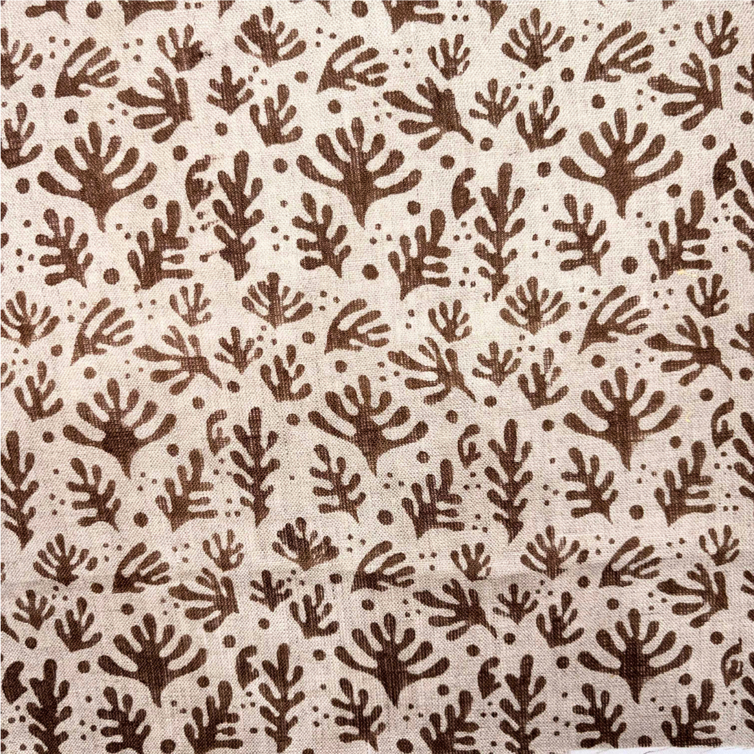 Patterned fabric with brown leaf-like shapes on a beige background