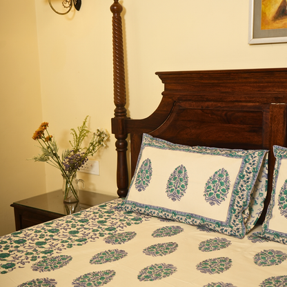 Bed with floral bedding and pillows in a bedroom setting.